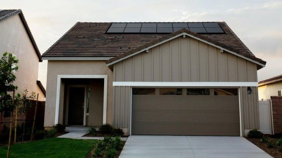 Haus mit Garagenanbau und einigen Solarpanels auf dem Dach