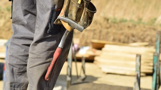 Hammer hängt an der Hose eines Bauarbeiters