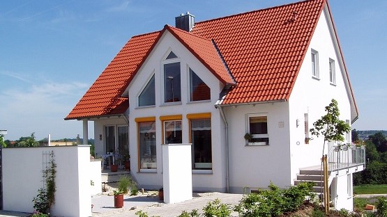 Neues Einfamilienhaus mit vielen Fenstern und weißer Fassade