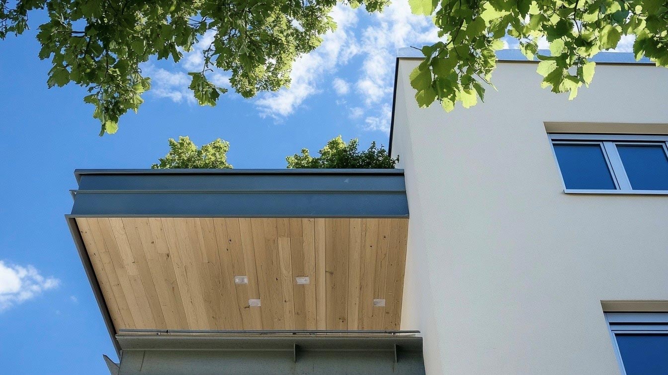 Blick auf Balkon eines kubischen Neubaus von unten.